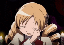 a girl with blonde hair is smiling and covering her face with her hand .