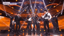 a group of young men are standing on a stage .