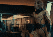 a man in a yellow and black superhero costume with a letter g on his belt