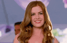 a woman with long red hair is smiling and wearing a white top .