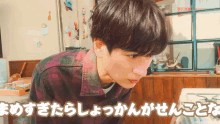 a man in a plaid shirt is looking down at something in a room with chinese writing