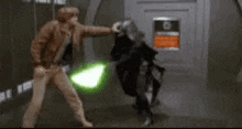 a man with a green lightsaber is fighting another man with a black helmet