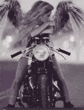 a black and white photo of a woman with angel wings on a motorcycle