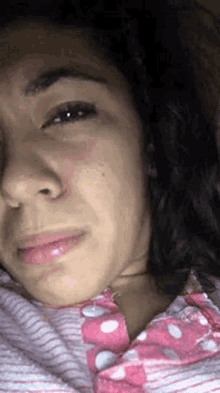 a woman is crying with a tear running down her face .