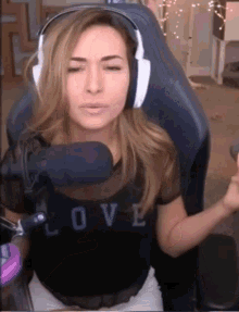 a woman wearing headphones is sitting in front of a microphone in a chair .
