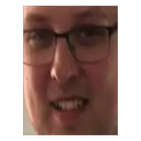 a close up of a man 's face with glasses and a smile .