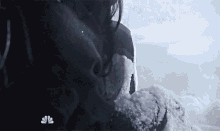 a close up of a person 's face with a nbc logo on the bottom