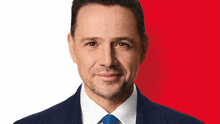 a man in a suit and tie with a red background