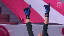 a person wearing blue gloves is giving a thumbs up .