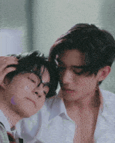 a couple of young men are laying next to each other .