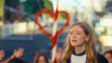 a woman is crying while holding a heart shaped pretzel stick .