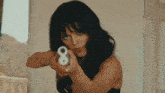 a woman is pointing a gun at the camera with the number 8 on it
