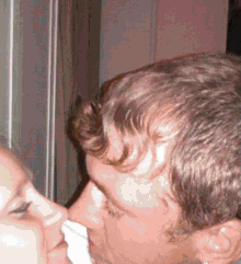 a man and a woman are kissing with a napkin between them