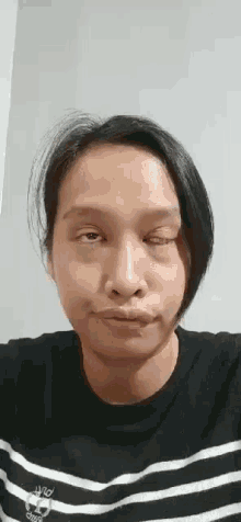 a woman is making a funny face with her eyes closed .