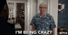 a man says i 'm being crazy in front of a netflix sign