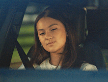 a woman is sitting in the back seat of a car with her eyes closed