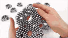 a person is playing with a bunch of metal balls