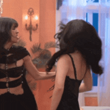 two women are standing next to each other and one is wearing a black dress