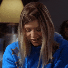 a woman wearing a blue shirt with stars on it