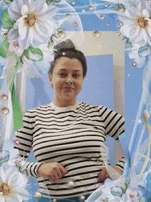 a woman in a striped shirt stands in front of a blue background with flowers