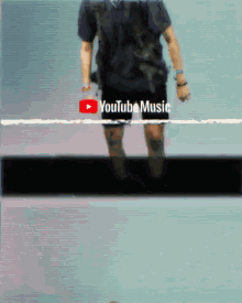 a person standing in front of a youtube music sign