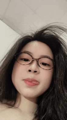 a woman wearing glasses looks at the camera