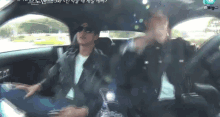a man in a leather jacket is sitting in the back seat of a car with sunglasses on .