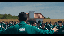 a man with 456 on his back stands in front of a crowd