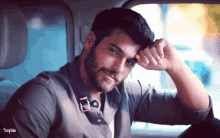 a man with a beard is sitting in the back seat of a car