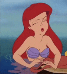a cartoon of ariel from the little mermaid yawning in the ocean .