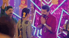 a man and a woman are standing next to each other in front of a crowd of people .