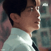 a close up of a man 's face with a jtbc logo behind him