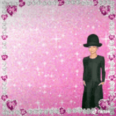 a girl in a black dress and top hat is standing in front of a pink background