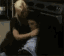 a man and a woman are hugging each other in a dark room .