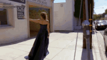 a woman in a blue dress is standing in front of a building that says real housewives