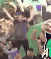 a group of people are dancing in front of a green wall with the letter a visible