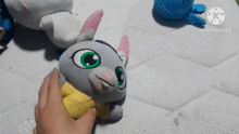 a person is touching a stuffed animal with a yellow shirt and the words kinemaster on the bottom