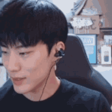 a young man wearing headphones is sitting in a chair and smiling .