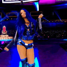 a woman with blue hair is standing on a stage holding a microphone ..