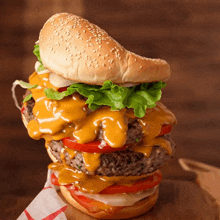 a hamburger with cheese lettuce tomatoes and onions on a bun