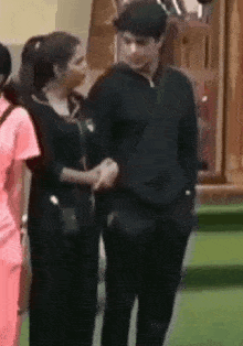 a man and a woman are shaking hands while standing next to each other on a grassy field .