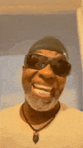 a man with a beard is wearing sunglasses and a beanie .