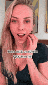 a woman in a black shirt is talking in spanish