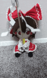 a stuffed doll in a red and white dress holding a sword
