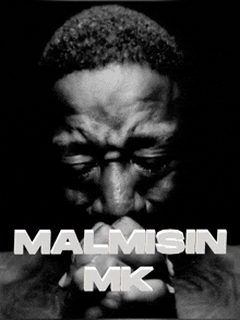 a black and white photo of a man with his eyes closed and the words malmisin mk written above him