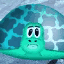 a cartoon turtle with a sad face is sitting on a concrete surface .
