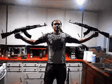 a man is standing in a kitchen holding two guns in his hands .