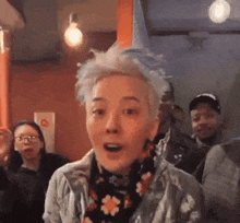 a woman with short hair is standing in front of a crowd of people .