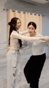 a couple of women are dancing together in a room .