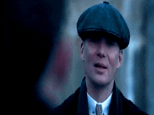 a close up of a man wearing a hat and tie .
